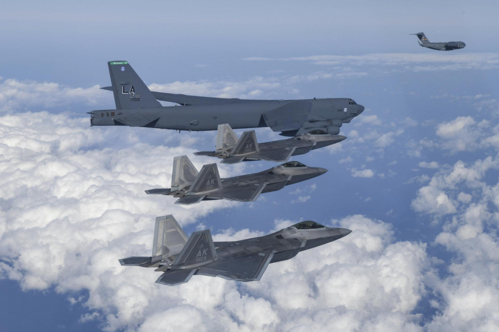 Na archívnej snímke z 20. decembra 2022 zeverejnenej juhokórejským ministerstvom obrany americký bombardér B-52H (hore) letí vo formácii s americkými stíhačkami F-22. FOTO TASR/AP
