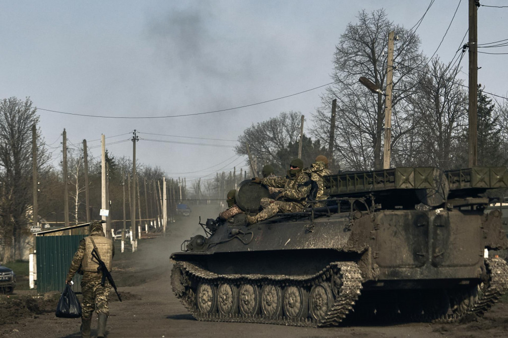 Ukrajinskí vojaci jazdia na obrnenom vozidle počas ťažkých bojov medzi ukrajinskou a ruskou armádou v meste Bachmut. FOTO: TASR/AP