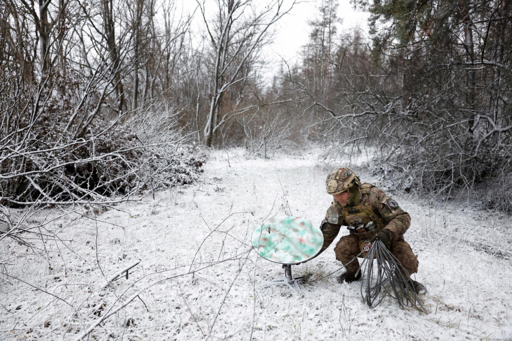 Ukrajinskí vojak inštaluje zariadenie na prijímanie signálu zo satelitov Starlink. FOTO: Reuters