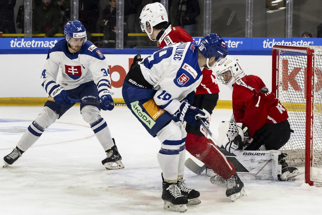 Slovensk&yacute; hokejista Peter Cehl&aacute;rik (vľavo) strieľa g&oacute;l &scaron;vajčiarskemu brank&aacute;rovi Connorovi Hughesovi v pr&iacute;pravnom z&aacute;pase pred MS v Rige &Scaron;vajčiarsko - Slovensko. FOTO: TASR/AP