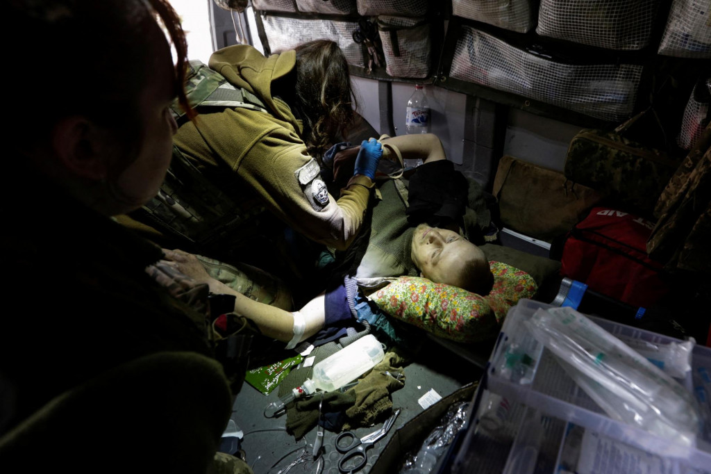 Zdravotníci pomáhajú zranenému ukrajinskému vojakovi pred jeho evakuáciou v Doneckej oblasti. FOTO: Reuters