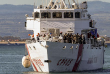 Loď talianskej pobrežnej stráže Peluso sa plaví do prístavu v Catanii na Sicílii s 300 migrantmi na palube, ktorých zachránili v mori. FOTO TASR/AP
