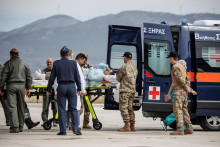 Zraneného gréckeho štátneho príslušníka, ktorý bol evakuovaný zo Sudánu, prevážajú sanitkou po prílete na vojenské letisko v Elefsine v Grécku. FOTO: Reuters