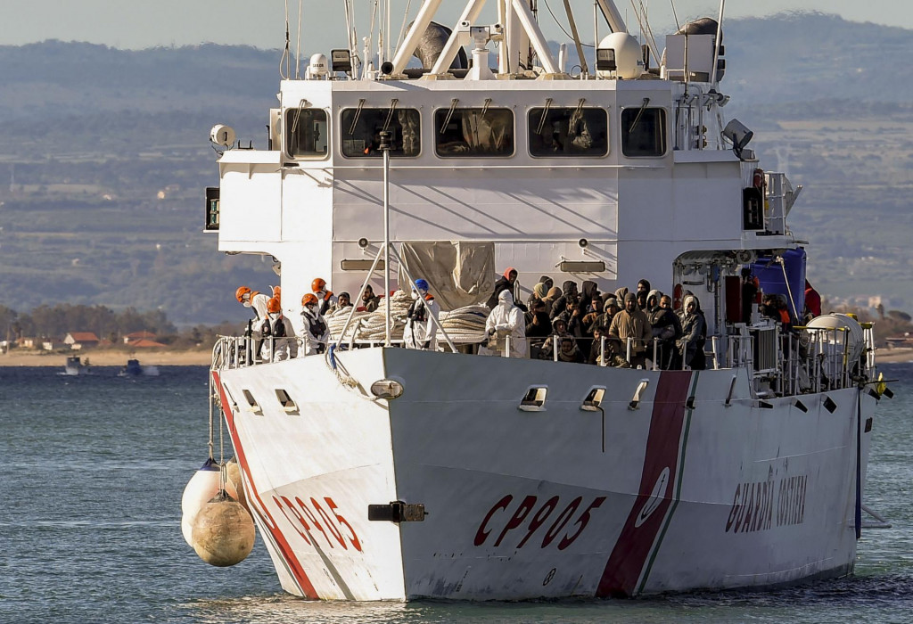 Loď talianskej pobrežnej stráže Peluso sa plaví do prístavu v Catanii na Sicílii s 300 migrantmi na palube, ktorých zachránili v mori. FOTO TASR/AP