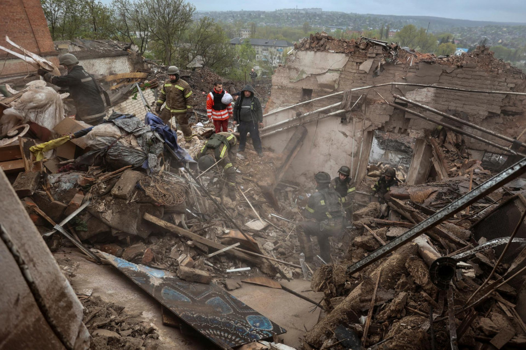 Záchranári a dobrovoľníci pracujú na mieste budovy miestneho múzea ťažko poškodenej ruským raketovým útokom v meste Kupiansk. FOTO: Reuters