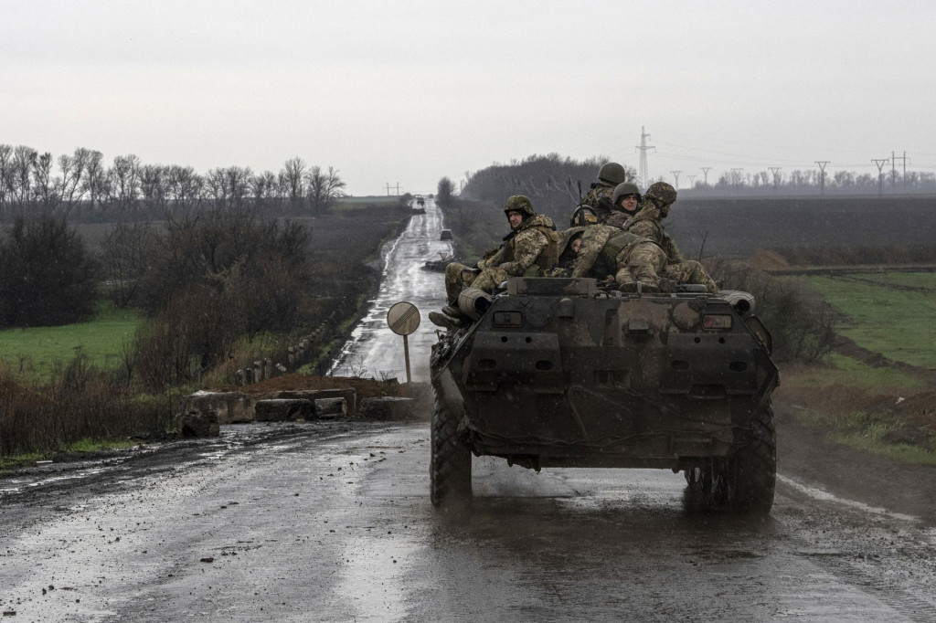 krajinskí vojaci sedia na vojenskom obrvenom vozidle, ktoré smeruje na front pri ukrajinské mesto Vuhledar. FOTO: TASR/AP
