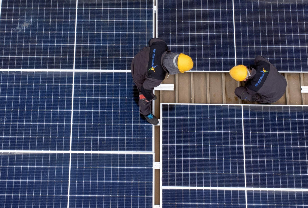Robotníci inštalujú solárne panely. FOTO: REUTERS