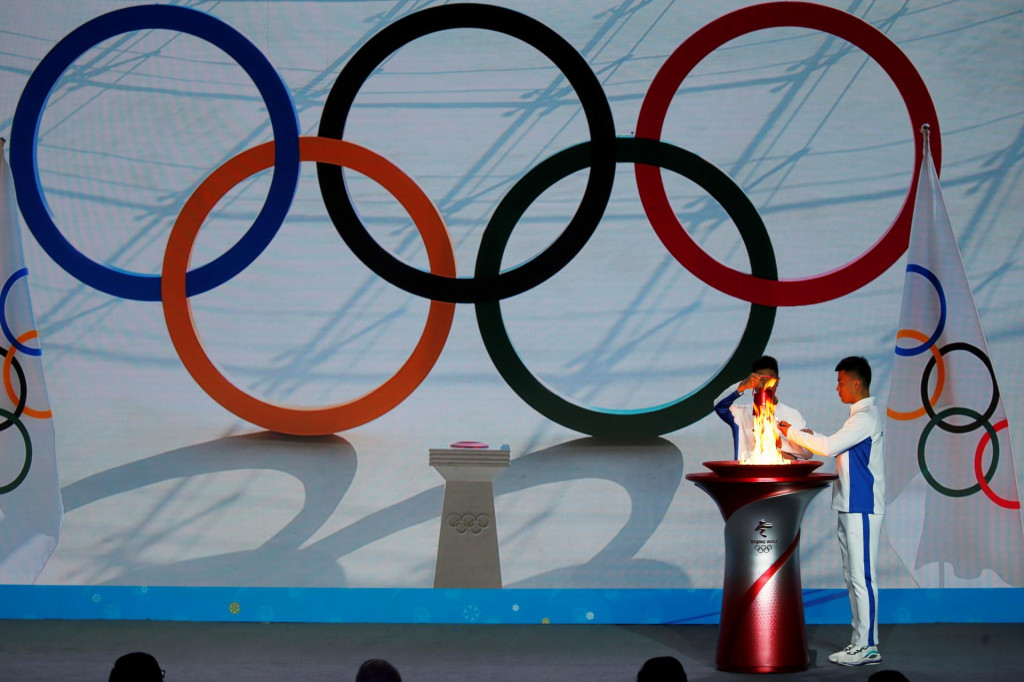 Účastníci počas slávnostnej ceremónie vítajú olympijský oheň na Zimných olympijských hrách v Pekingu v roku 2022. FOTO: Reuters