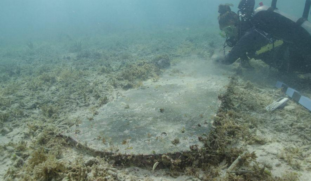 Potápači pod vodou našli náhrobný kameň.