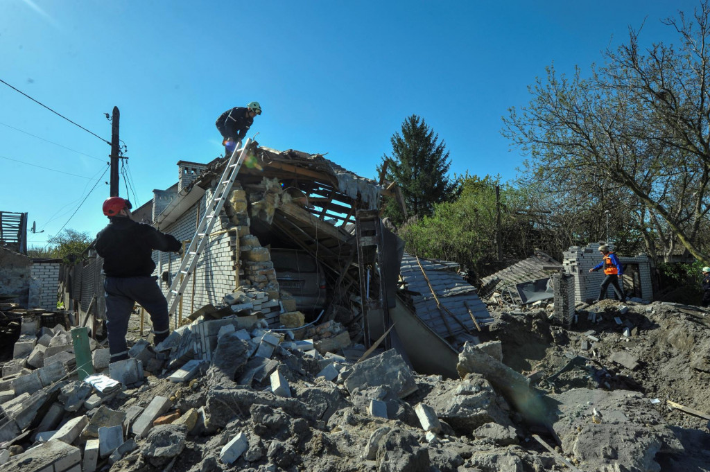 Záchranári pracujú na mieste obytnej štvrte ťažko poškodenej ruským raketovým útokom. FOTO: Reuters