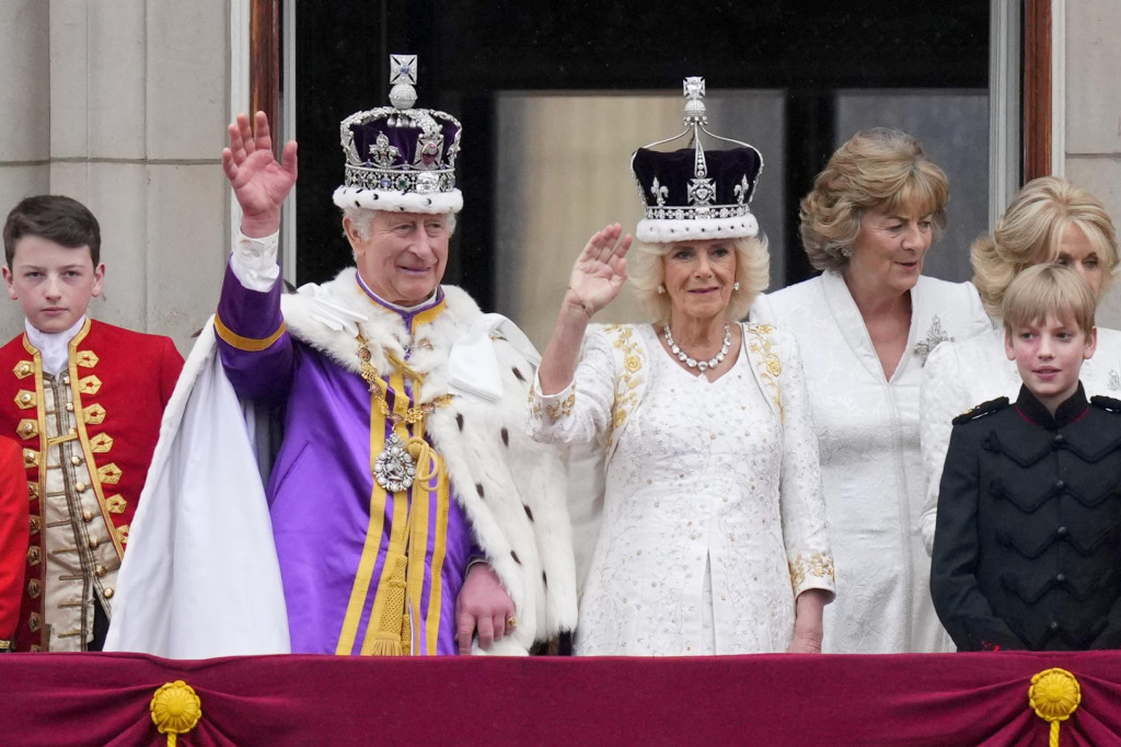 Britský kráľ Karol III. a britská kráľovná Kamila zdravia verejnosť z balkóna Buckinghamského paláca na záver korunovačných ceremónií v Londýne. FOTO: TASR/AP