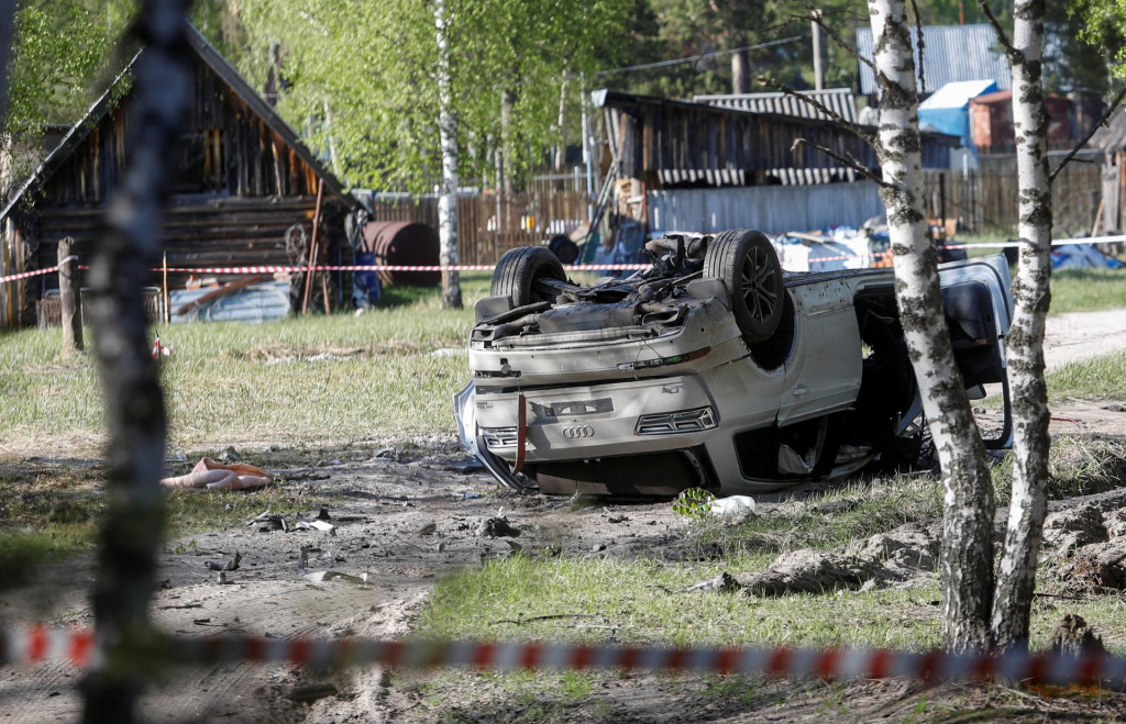 Poškodené biele auto Audi Q7 ležiace prevrátené vedľa lesa po útoku na ruského nacionalistického spisovateľa Zachara Prilepina. FOTO: Reuters