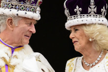 Britský kráľ Karol III. a britská kráľovná Kamila sa usmievajú na balkóne Buckinghamského paláca na záver korunovačných ceremónií v Londýne. FOTO: TASR/AP