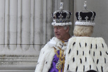 Britský kráľ Karol III. a britská kráľovná Kamila sa rozprávajú na balkóne Buckinghamského paláca na záver korunovačných ceremónií v Londýne. FOTO: TASR/AP