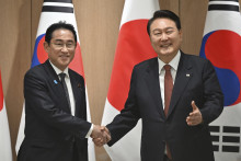 Japonský premiér Fumio Kišida (vľavo) a juhokórejský prezident Jun Sok-jol pózujú počas stretnutia v Soule. FOTO: TASR/AP