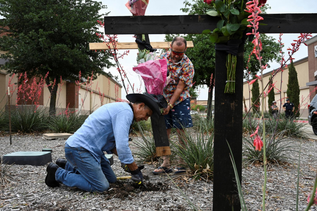 Muralista Roberto Marquez a jeho priateľ Israel Gil z Dallasu stavajú pamätník na počesť tých, ktorí prišli o život, keď strelec zastrelil viacero ľudí v obchodnom centre Allen Premium Outlets v Allene v Texase. FOTO: Reuters