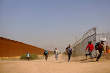 Migranti sa utekajú skryť pred americkou pohraničnou hliadkou a texaskou národnou gardou po prechode do Spojených štátov z Mexika v El Paso. FOTO: Reuters