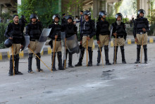 Policajti strážia pred kancelárskou budovou Rádia Pakistan po tom, čo ju podpálili priaznivci pakistanského bývalého premiéra Imrana Khana počas protestu proti jeho zatknutiu. FOTO: Reuters