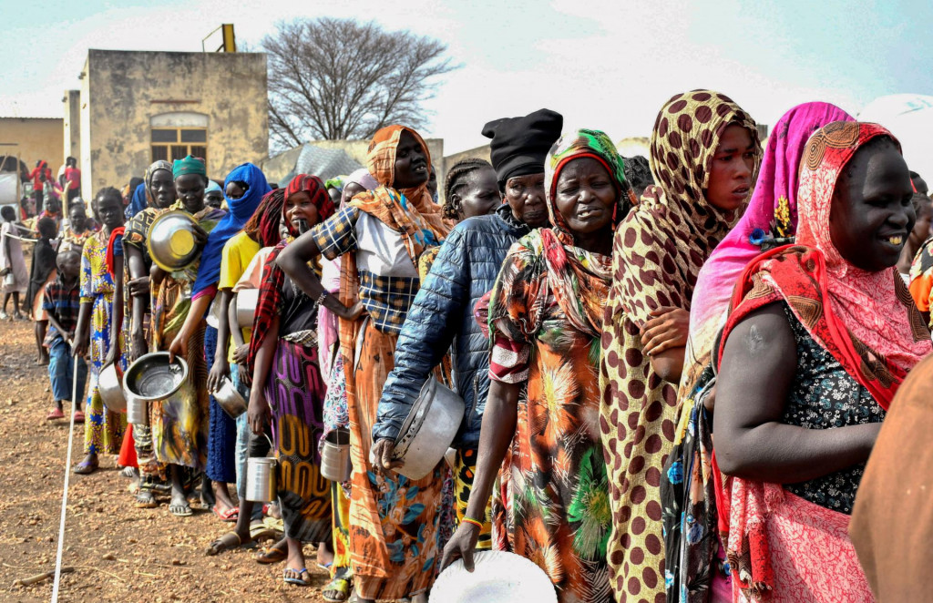 Ženy, ktoré utiekli z vojnou zničeného Sudánu po vypuknutí bojov medzi sudánskou armádou a polovojenskými jednotkami rýchlej podpory, sa tlačia v rade, aby dostali prídely jedla. FOTO: Reuters