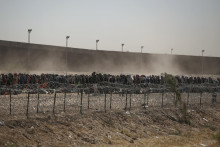 Migranti stoja v rade medzi ostnantým drôtom a hraničným múrom v Ciudad Juáreze, mexickom pohraničnom meste so Spojenými štátmi. FOTO: TASR/AP