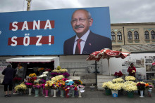 Pouliční predavači predávajú kvety pod bilbordom lídra prosekulárnej centroľavicovej Republikánskej ľudovej strany a prezidentského kandidáta Kemala Kiličdaroglua. FOTO: TASR/AP
