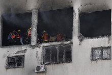 Palestínski hasiči hasia požiar obytnej budovy, ktorú zasiahla raketa izraelskej armády v Gaze. FOTO: TASR/AP