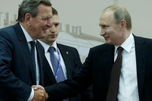 Ruský prezident Vladimir Putin si podáva ruku a bývalý nemecký kancelár Gerhard Schröder v roku 2016. FOTO: Reuters
