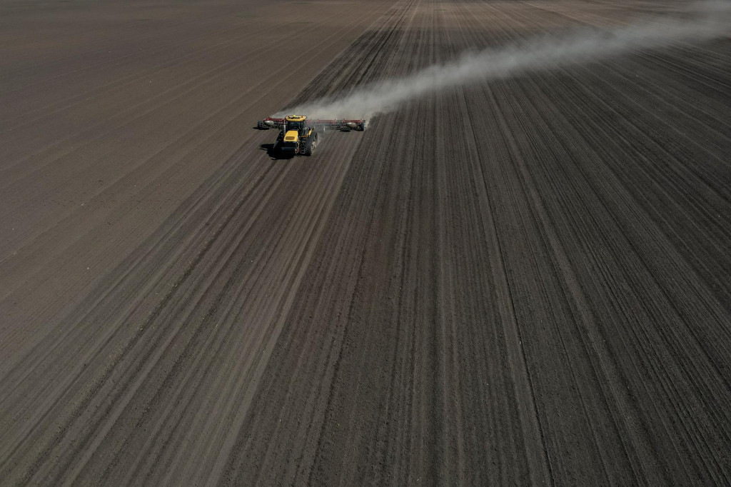 Poľnohospodársky robotník obsluhuje traktor s kultivátorom na poli pri obci Kyshchentsi v Čerkaskej oblasti. FOTO: Reuters