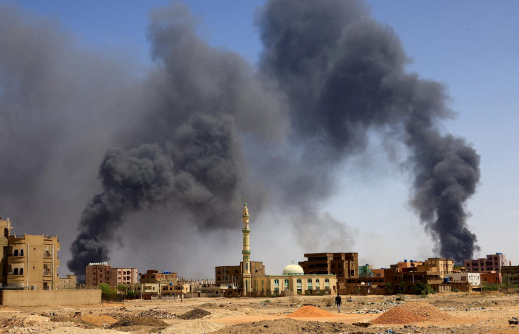FILE PHOTO: A man walks while smoke rises above buildings after aerial bombardment, during clashes between the paramilitary Rapid Support Forces and the army in Khartoum North, Sudan, May 1, 2023. REUTERS/Mohamed Nureldin Abdallah/File Photo/File Photo SN&Iacute;MKA: Mohamed Nureldin Abdallah