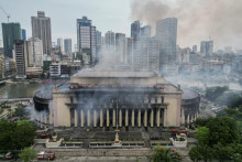 Z horiacej budovy centrálnej pošty v Manile stúpa dym po rozsiahlom požiari. FOTO: Reuters