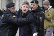 Bieloruskí policajti zadržiavajú aktivistu a novinára Ramana Prataseviča v Minsku. FOTO: TARS/AP