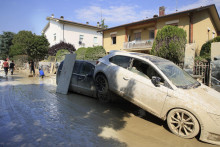Dve autá naskladané na strane cesty po rozsiahlych záplavách v talianskom meste Faenza. FOTO: TASR/AP