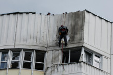 Pracovník zisťuje, aké škody na moskovskej obytnej budove spôsobil útok ukrajinských dronov. FOTO: Reuters