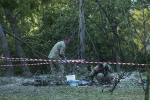 Policajti zbierajú dôkazy po raketovom útoku ruskej armády v Kyjeve. FOTO: TASR/AP