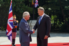 Britský kráľ Karol III. si podáva ruku s rumunským prezidentom Klausom Iohannisom. FOTO: Reuters