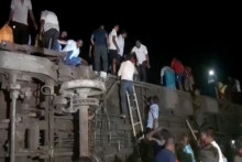 Ľudia sa pokúšajú utiecť z prevrátených vagónov po zrážke dvoch vlakov v Balasore v Indii. FOTO: ANI/Reuters