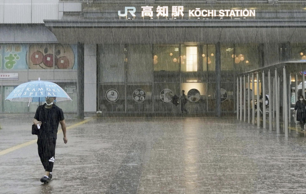 Muž kráča v silnom daždi počas príchodu tajfúnu Mawar v japonskom meste Koči, na južnom pobreží Japonska. FOTO: TASR/AP