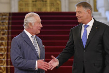 Britský kráľ Karol III. a rumunský prezident Klaus Iohannis si podávajú ruky počas uvítania v prezidentskom paláci v Bukurešti. FOTO: TASR/AP