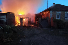 Hasiči pracujú na horiacom dome po ostreľovaní, ktoré podľa gubernéra spôsobili ukrajinské sily, v obci Sobolevska v regióne Belgorod. FOTO: Reuters