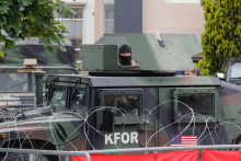 Americký člen kosovských síl pod vedením NATO stojí na stráži v obrnenom vozidle pred obecnými úradmi v Leposaviči v Kosove. FOTO: Reuters