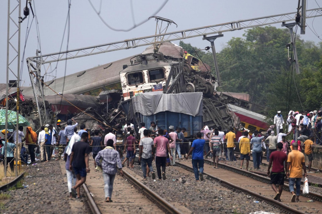 Záchranári pracujú na mieste nehody osobných vlakov v Balasore vo východoindickom štáte Urísa. FOTO: TASR/AP