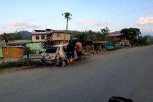 Ľudia stoja pri zhorenom vozidle v indickom Manipure. FOTO: Instagram/The_mj_rider