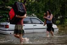 Obyvatelia Novej Kachovky utekajú pred povodňami po zničení priehrady. FOTO: Reuters