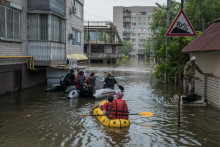 Miestni obyvatelia sa plavia na člnoch na zaplavenej ulici počas evakuácie po pretrhnutí priehrady Nova Kachovka. FOTO: Reuters