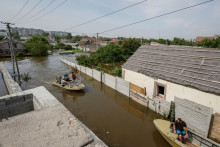 Miestni obyvatelia evakuujú osobné veci a domáce zvieratá zo zaplavenej oblasti po pretrhnutí priehrady Nová Kachovka. FOTO: Reuters