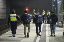 Švédsky policajt sprevádzajúci utečencov na stanici Hyllie v meste Malmö. FOTO: Reuters