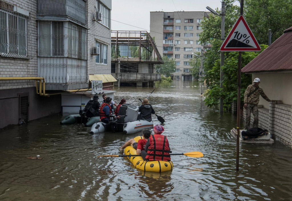 Miestni obyvatelia sa plavia na člnoch na zaplavenej ulici počas evakuácie po pretrhnutí priehrady Nova Kachovka. FOTO: Reuters