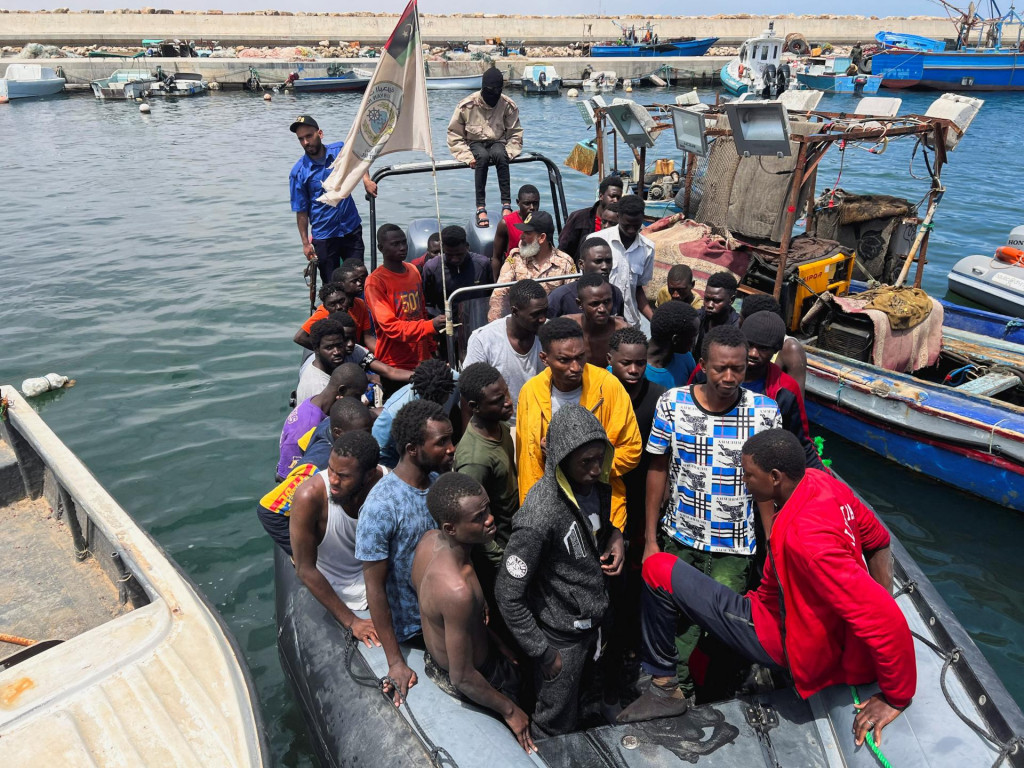 Migranti, ktorých člny sa potopili v mori a ktorých zachránila líbyjská pobrežná stráž v Stredozemnom mori, prichádzajú na člne do prístavu v Garaboli v Líbyi. FOTO: Reuters