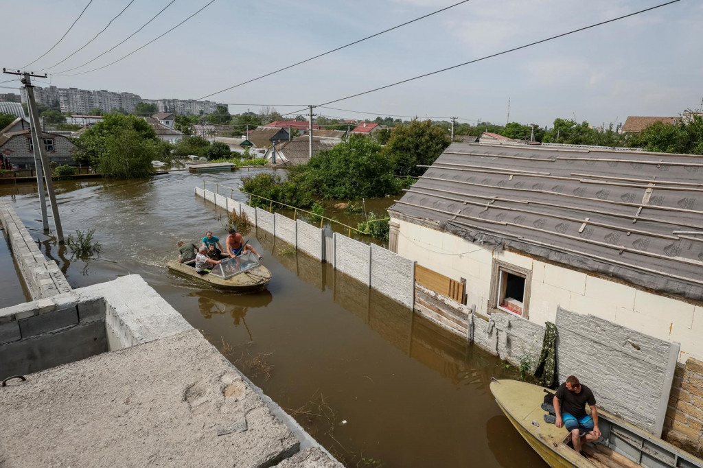Miestni obyvatelia evakuujú osobné veci a domáce zvieratá zo zaplavenej oblasti po pretrhnutí priehrady Nová Kachovka. FOTO: Reuters