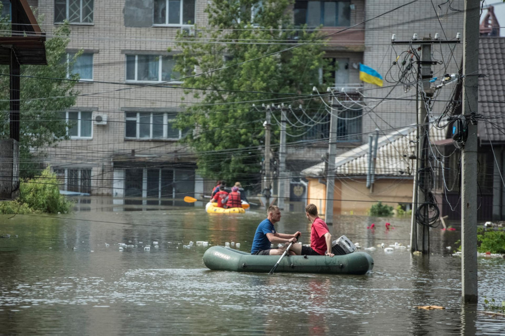 Miestni obyvatelia sa plavia na člnoch na zaplavenej ulici počas evaku&aacute;cie po pretrhnut&iacute; priehrady Nov&aacute; Kachovka. FOTO: Reuters